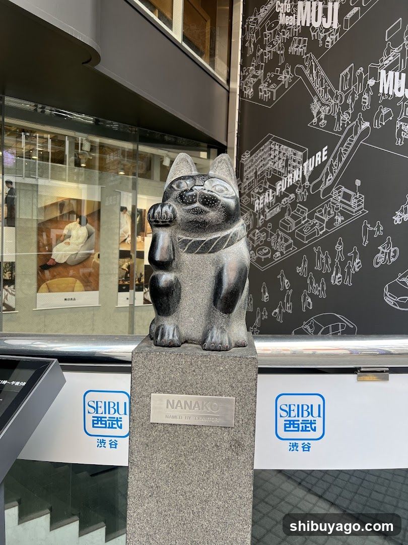 A black stone Nanako statue sits on a pedestal in front of the Seibu store entrance, with signage visible below and to the side.