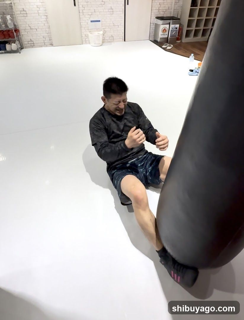 Man sitting on floor near punching bag