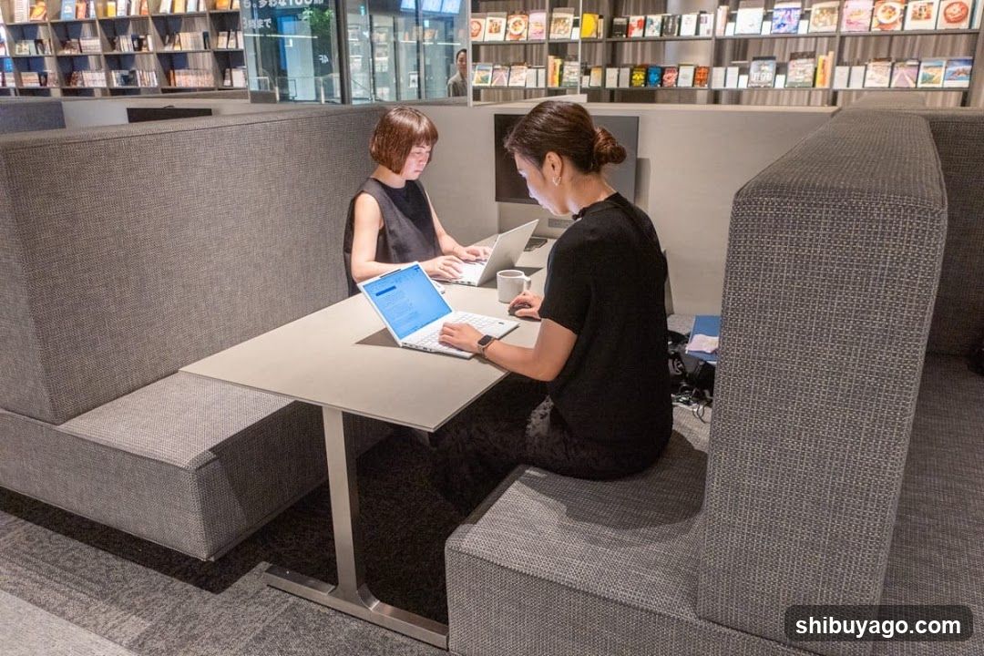 Two people working in a modern cafe booth