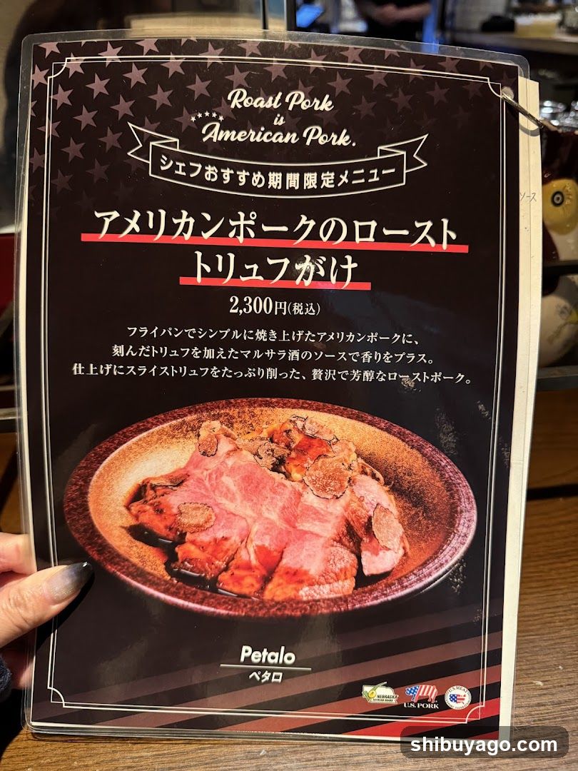 A close-up of a menu page featuring an American pork roast dish with truffle, priced at 2,300 yen (tax included). The menu includes Japanese and English text describing the dish.