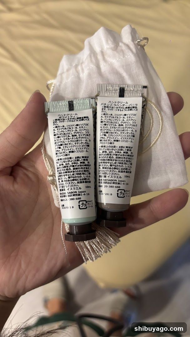 Hand holding two tubes of hand cream