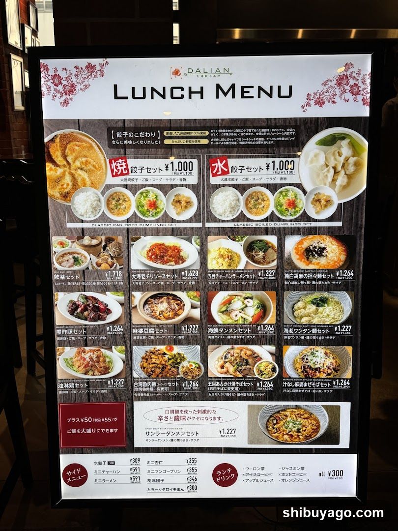 A vertical menu board displaying lunch options at Dalian restaurant, featuring dumplings (gyoza), rice bowls, and noodle dishes with prices in yen.