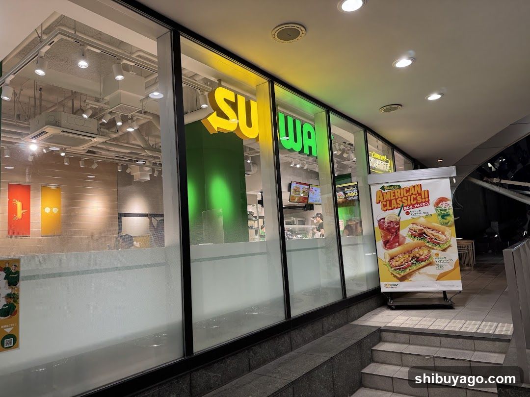 Photo of physical exterior entrance/storefront facade with visible shop signage on the building.