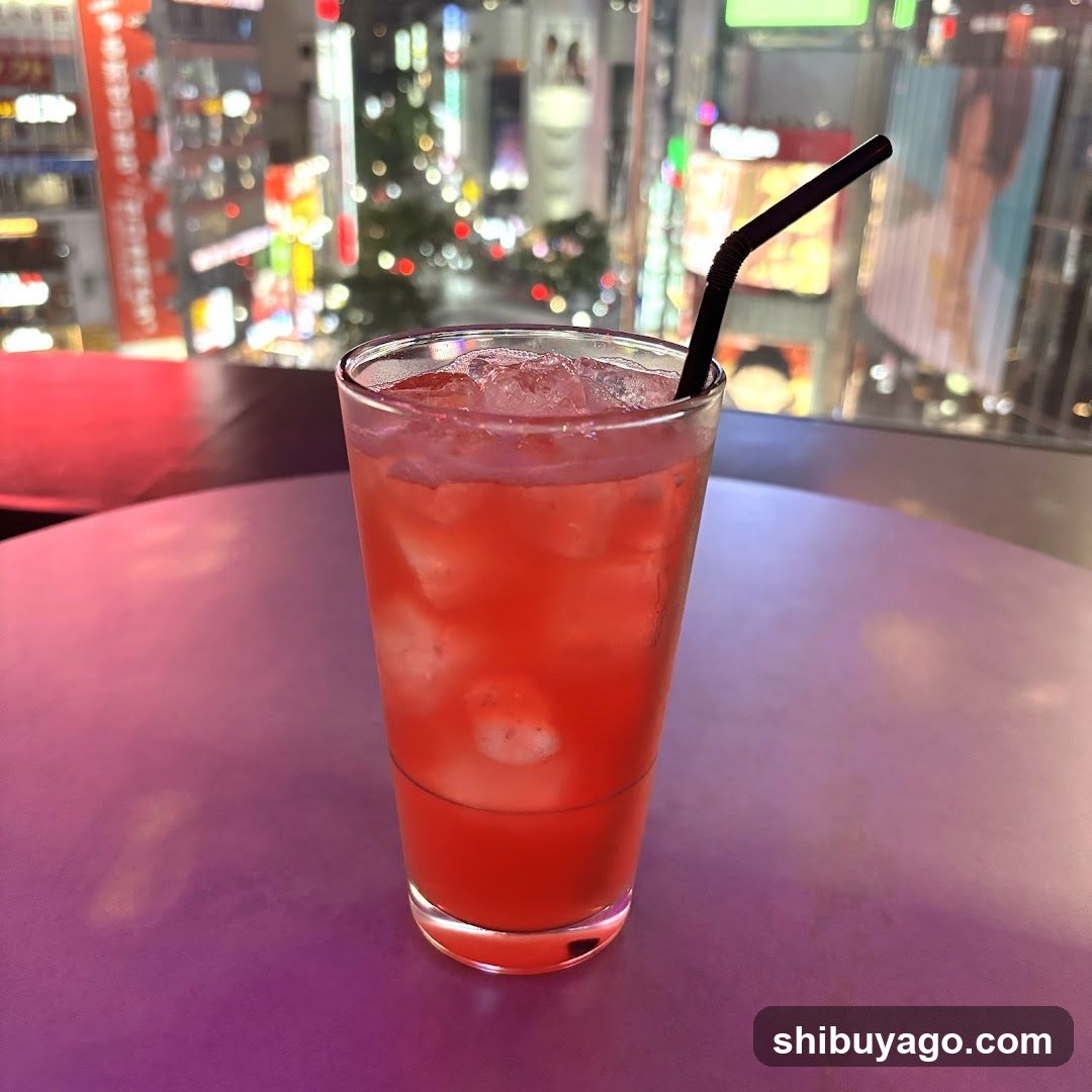 Red cocktail in glass with city view