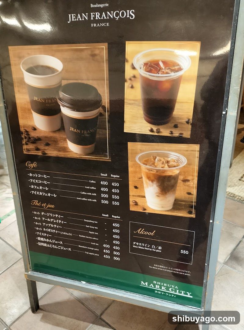 A menu board displaying coffee and tea options with prices in yen, featuring images of hot and iced beverages.