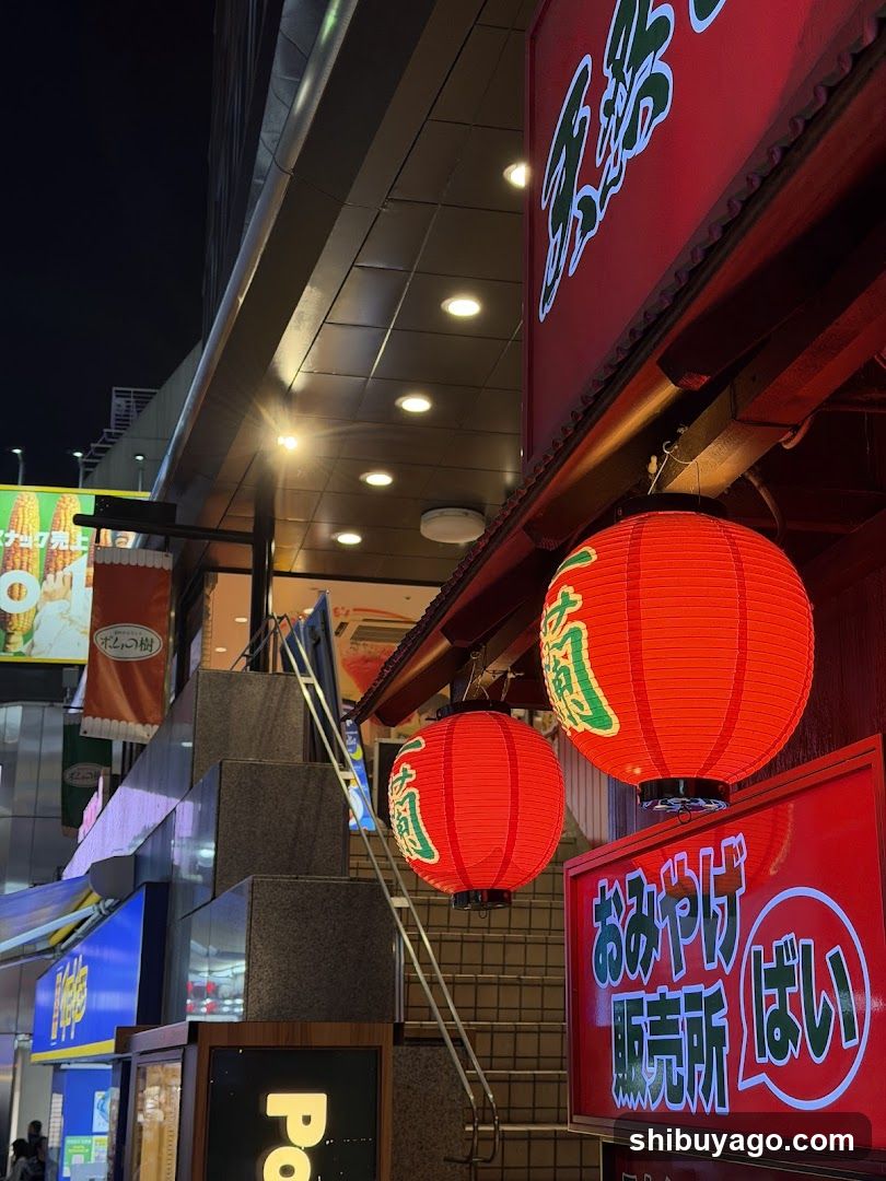 Nighttime storefront with red lanterns and signage