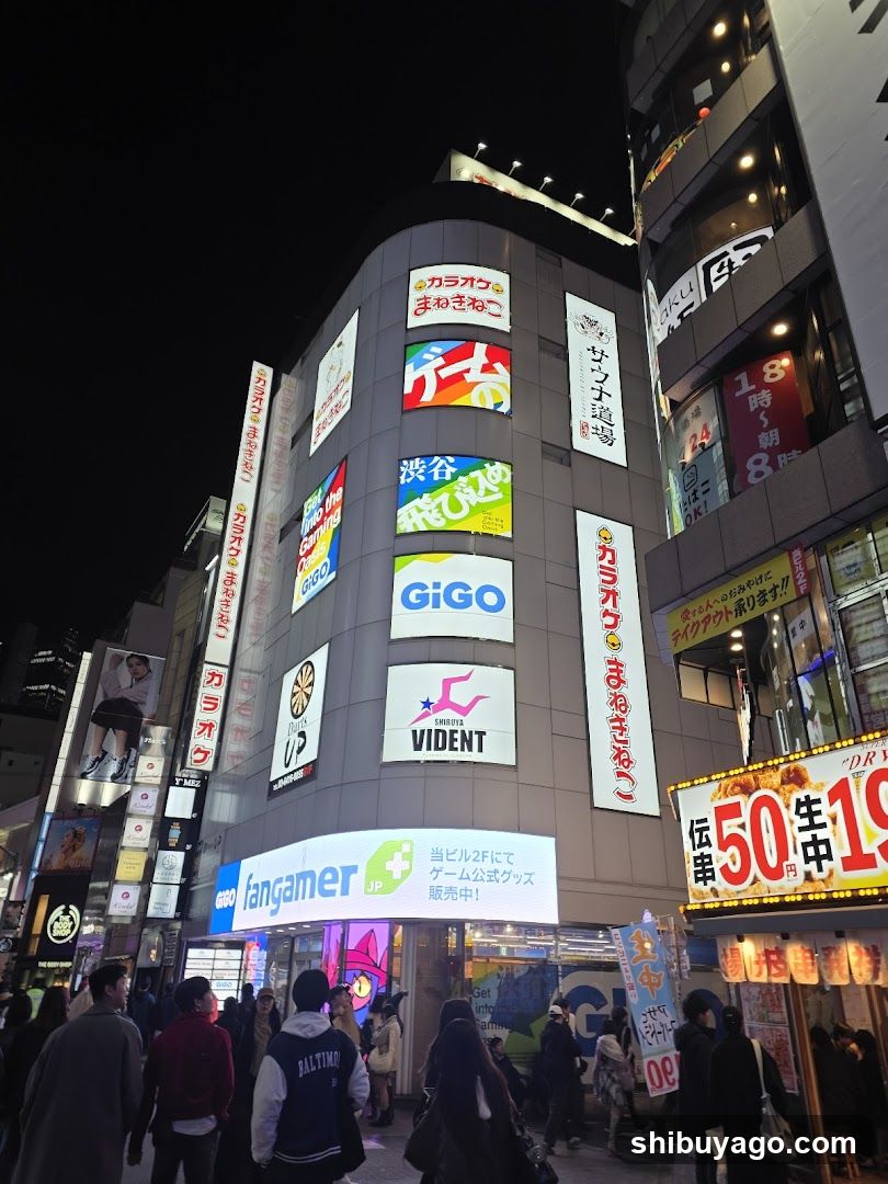 Night street scene with illuminated building facade and crowd