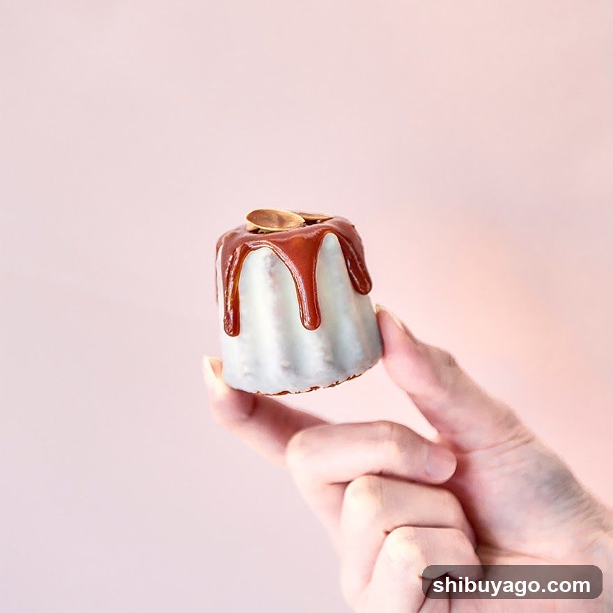 Hand holding a small dessert with caramel drizzle