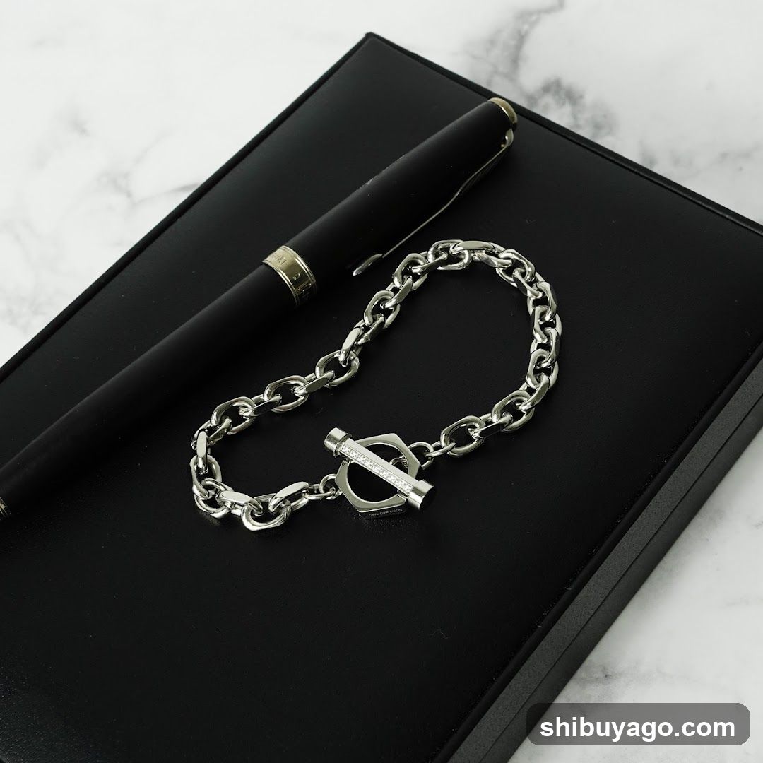 Silver Chain Bracelet and Pen on Black Surface