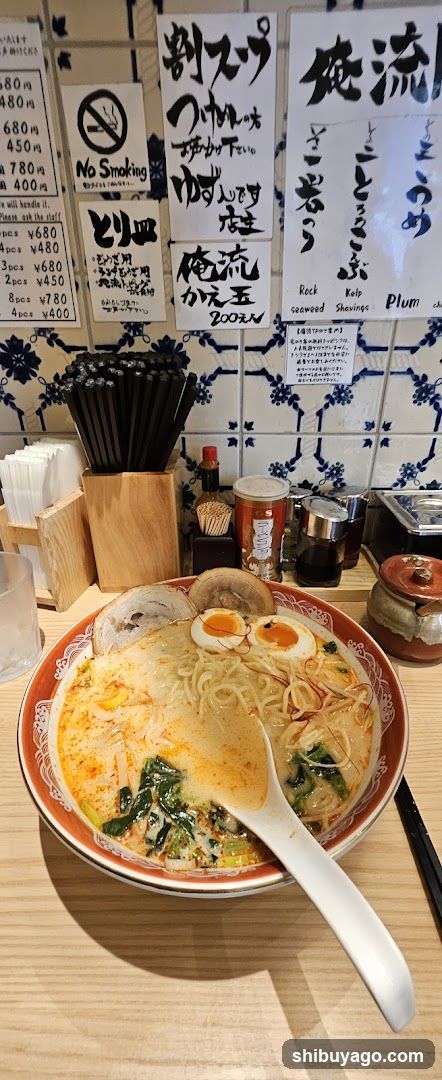 Ramen Bowl with Menu Board in Background