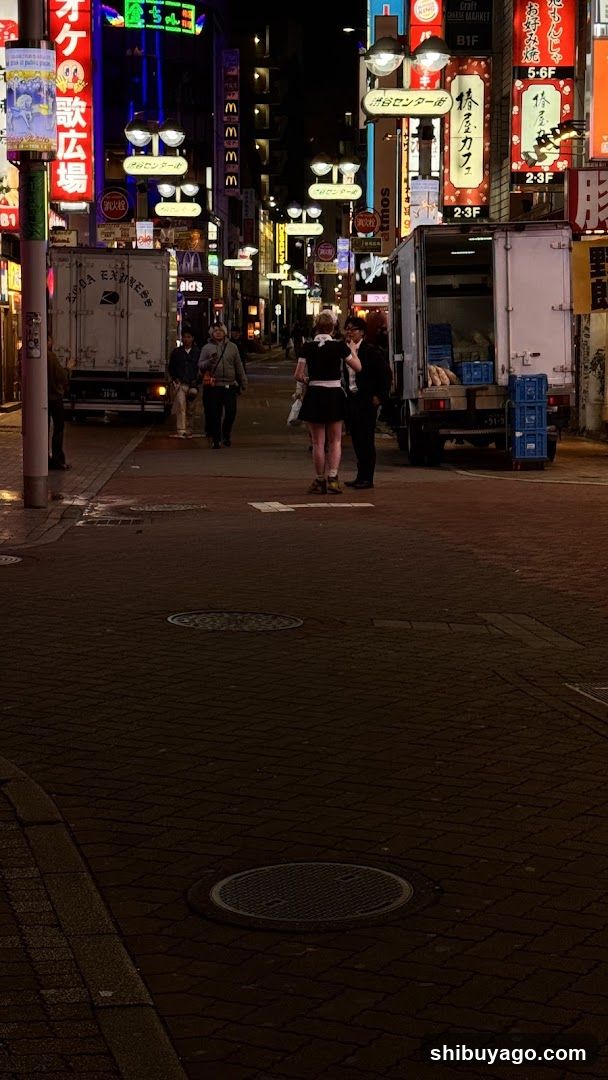 Night Street Scene with Neon Signs and Trucks