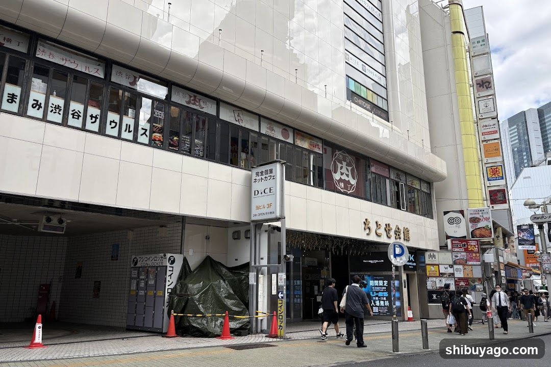 A building with multiple shops and a covered entrance.