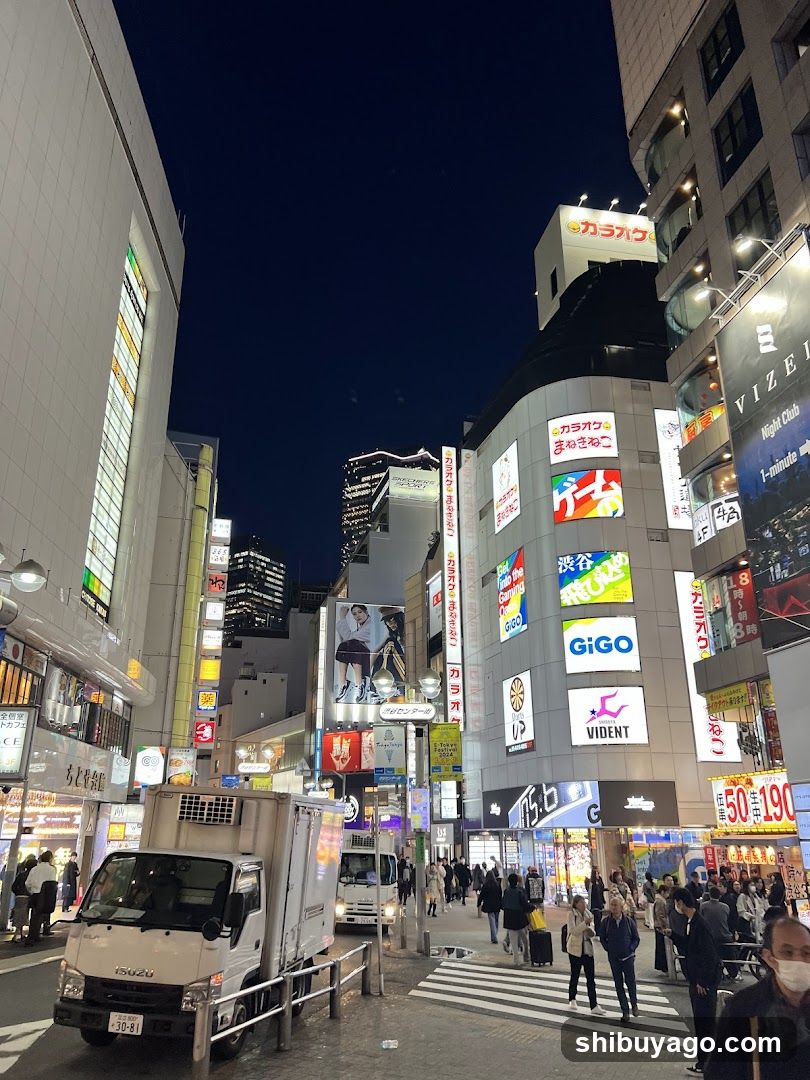 Night street scene with illuminated billboards and storefronts