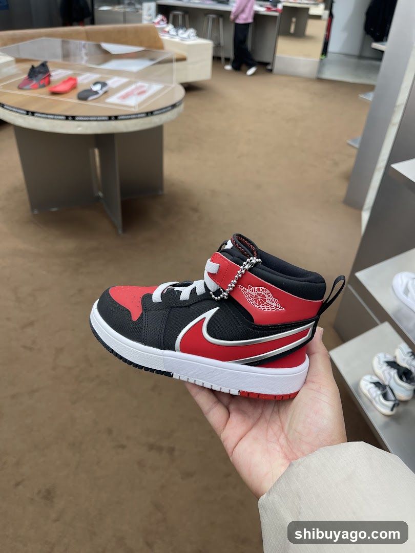 Hand holding red and black sneaker in store