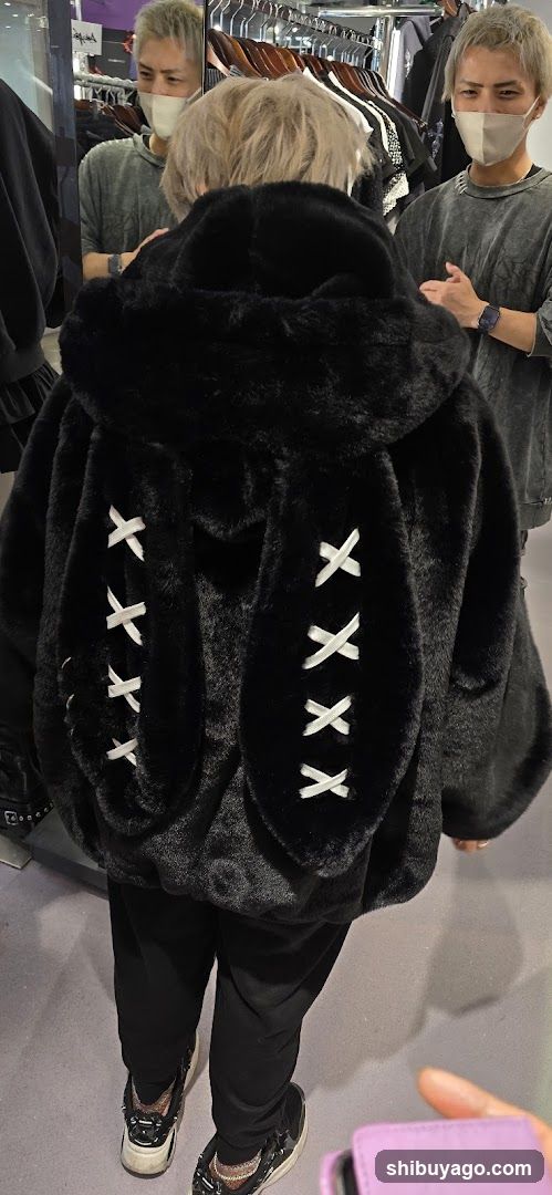 Person in a black furry jacket with white X laces