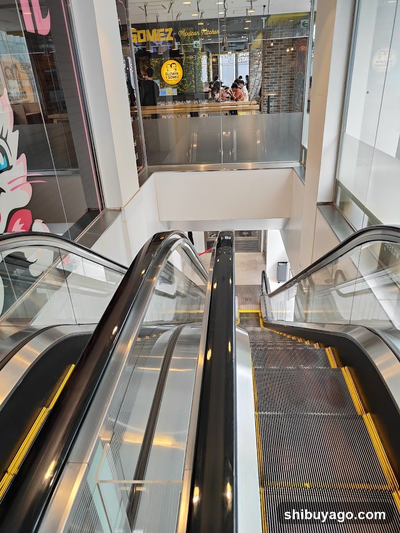 Shopping Center Interior with Escalators and Storefronts