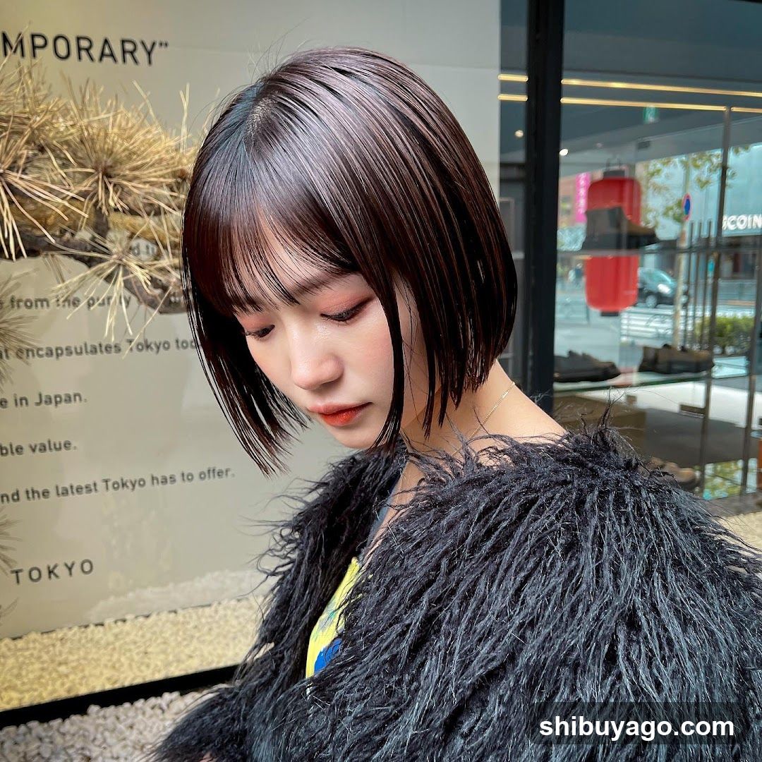 Woman with short dark hair and black fur coat