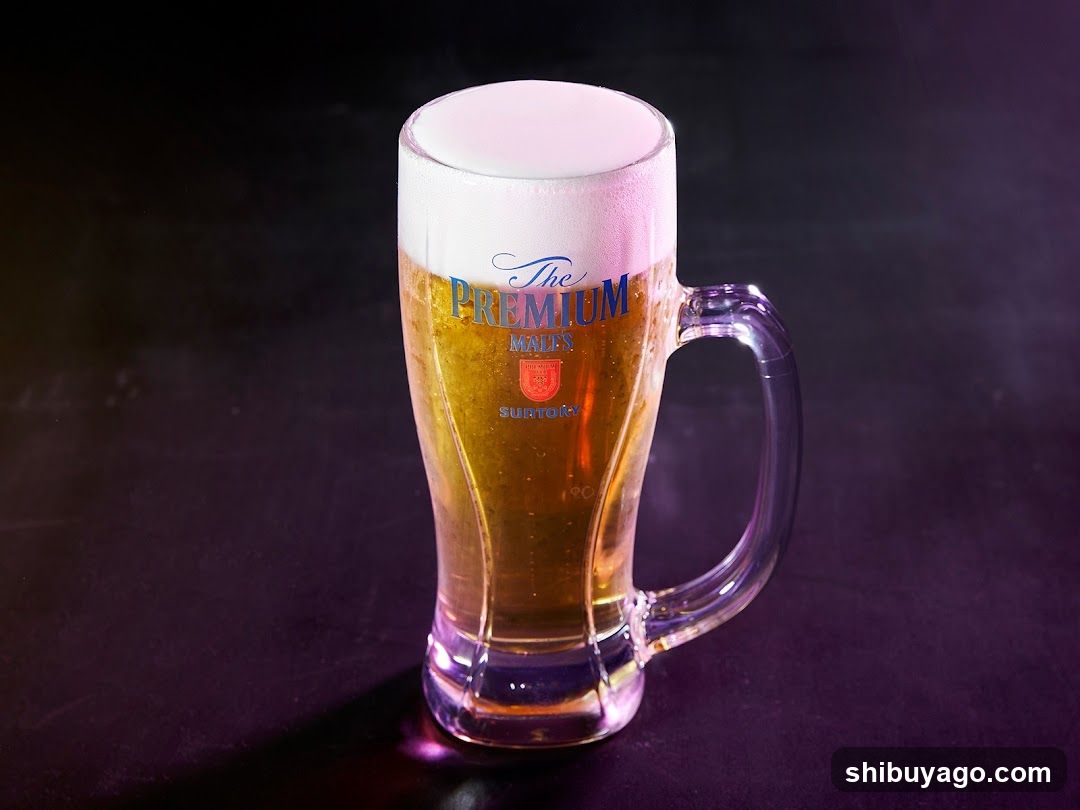 A glass mug filled with golden beer topped with a thick white foam head, featuring the label 'The PREMIUM MALL'S SURTONE' on its side.