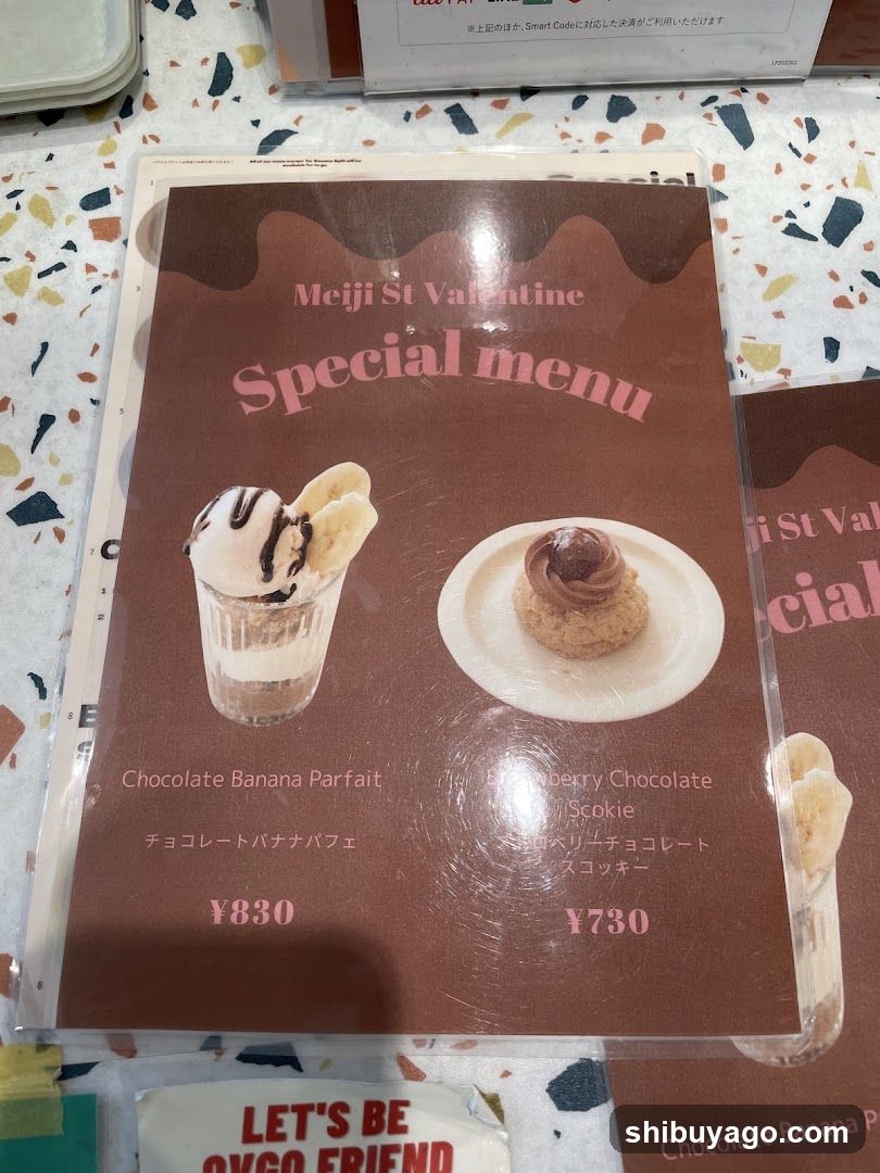 A close-up of a brown paper menu featuring two dessert items with prices in yen, placed on a speckled table surface.