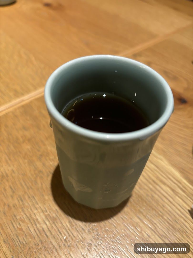 Cup of dark liquid on wooden table