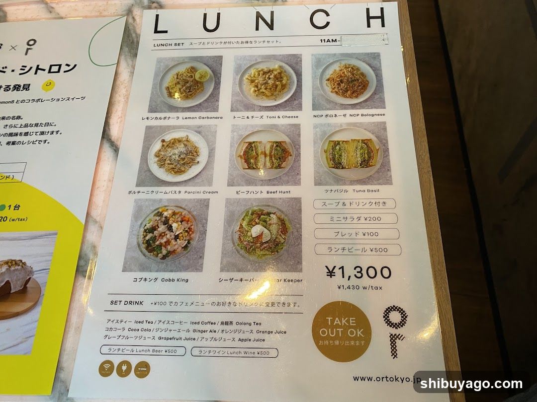 A printed lunch menu featuring six main dishes with photos, descriptions in Japanese and English, and prices ranging from ¥1,300 to ¥500 for set drinks.