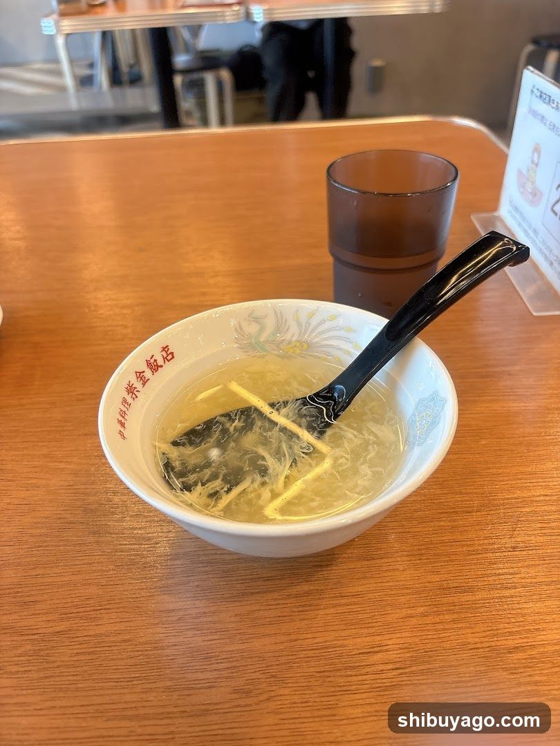 Soup Bowl with Chopsticks and Glass on Wooden Table