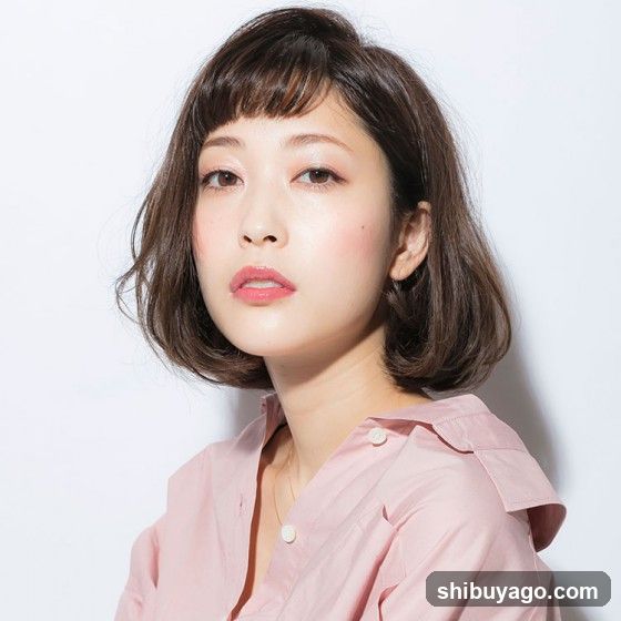 Portrait of a woman with short hair and pink blouse