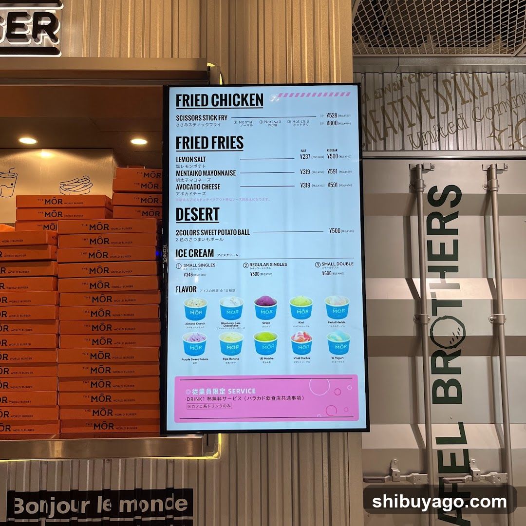 A digital menu board displaying fried chicken, fries, dessert options (sweet potato ball), and ice cream flavors with prices in yen.