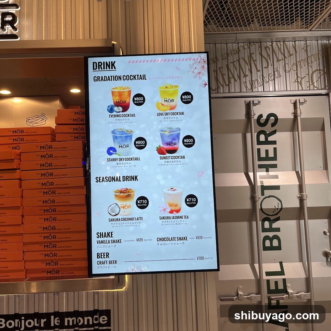 Digital menu board at MOR (Morimoto) restaurant showing drinks including Gradation Cocktails, Seasonal Drinks, Shakes, and Beer.