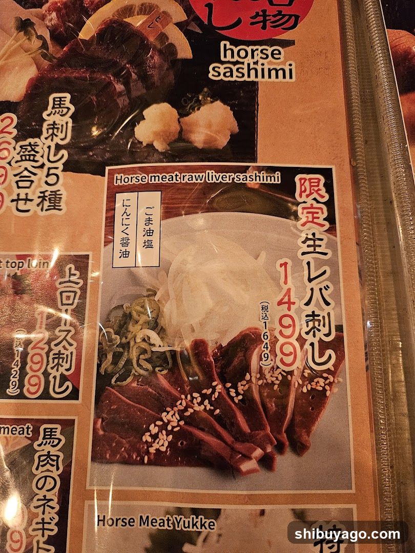 Close-up of a Japanese restaurant menu featuring horse meat sashimi dishes, including 'Horse meat raw liver sashimi' priced at ¥1499 and 'Top Loin Horse Sashimi' at ¥2699. The menu includes English translations alongside Japanese text.