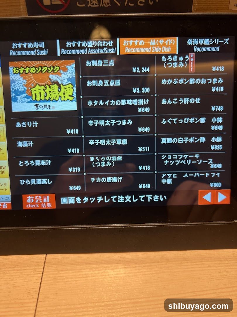 A digital menu board showing sushi and side dish options with prices in yen.