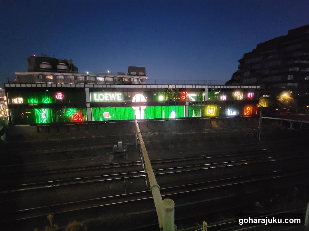 Night view of illuminated building facade near train tracks